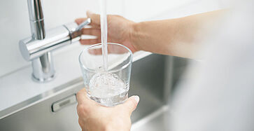 Woman filling glass of water
